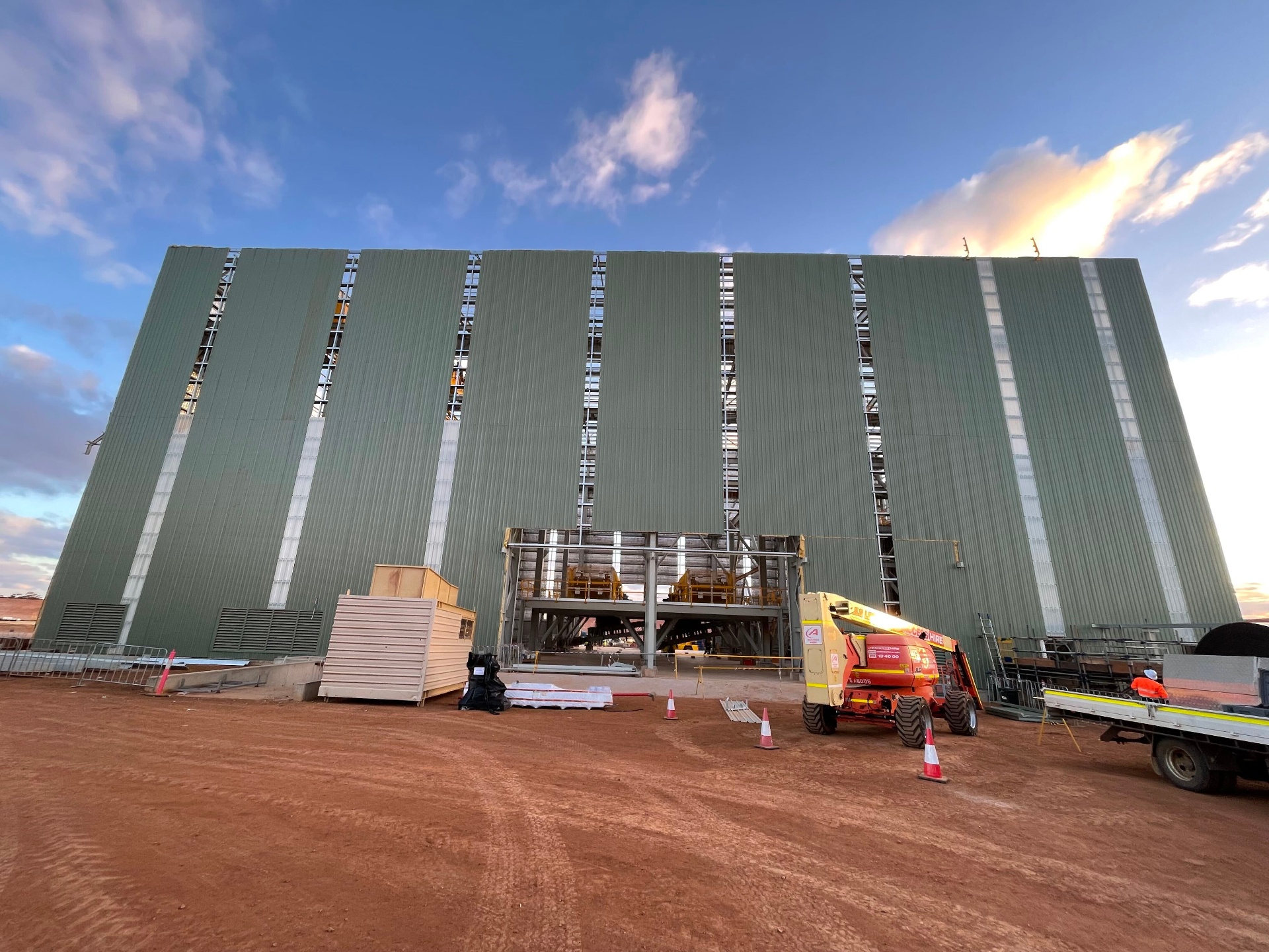 Tall metal wall cladding installation on a mining infrastructure building